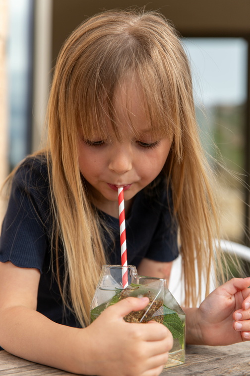 petite fille buvant du thé glacé à la pêche